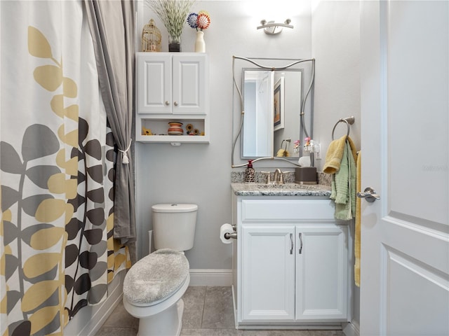 bathroom featuring tile flooring, vanity, and toilet