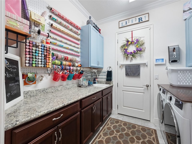 kitchen with crown molding, independent washer and dryer, light tile flooring, dark brown cabinetry, and sink