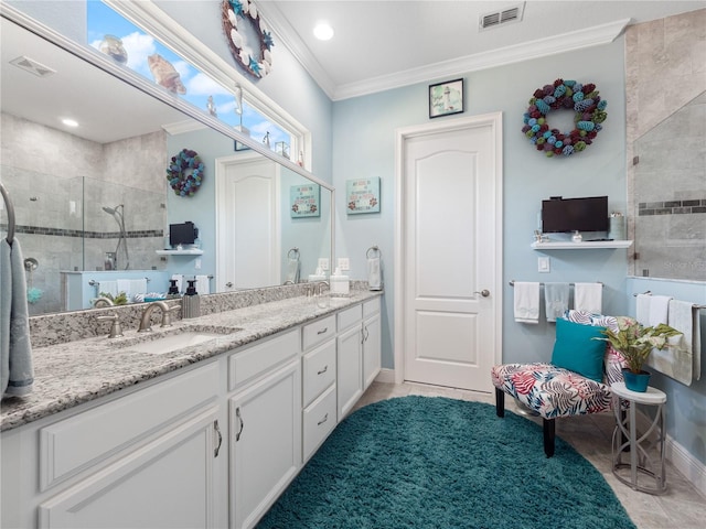 bathroom featuring tiled shower, double vanity, tile floors, and crown molding