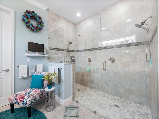 bathroom featuring tile floors, ornamental molding, and a shower with shower door