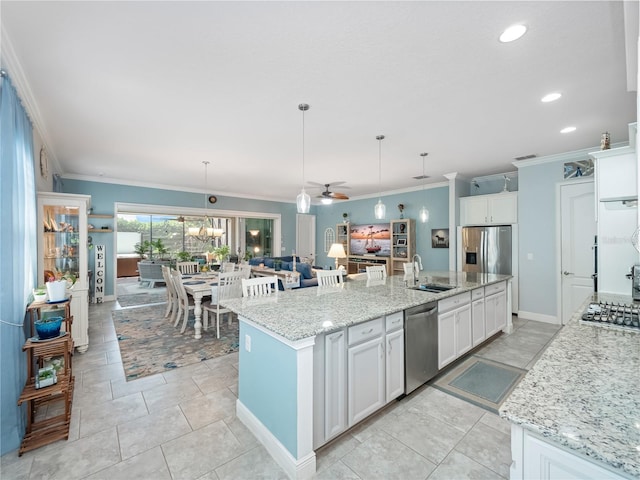 kitchen featuring stainless steel appliances, sink, a large island, and decorative light fixtures