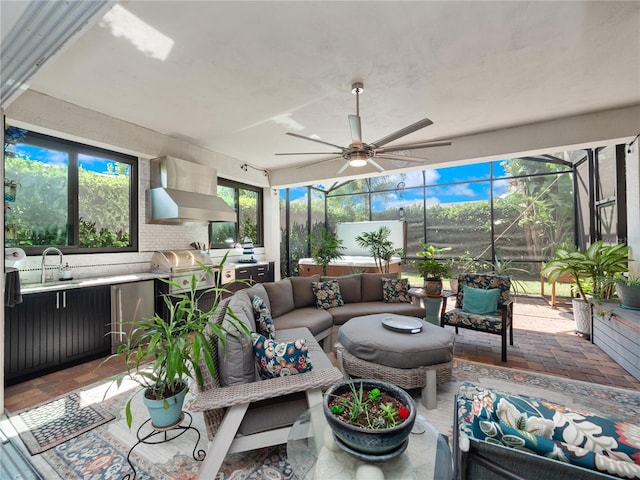 sunroom with ceiling fan and sink