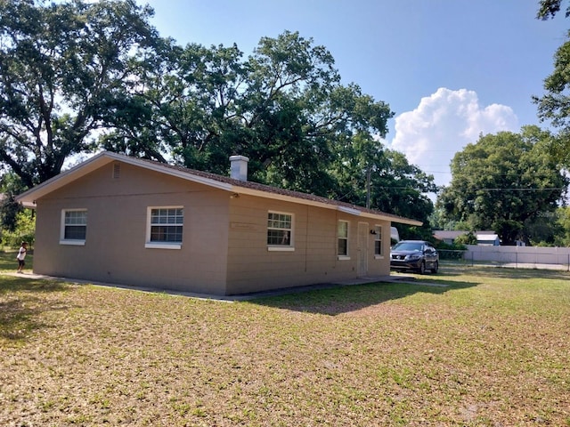 view of side of property with a lawn