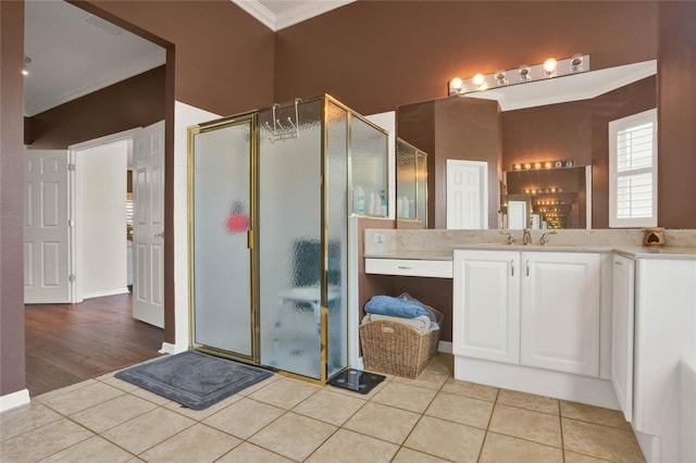 bathroom with walk in shower, ornamental molding, vanity with extensive cabinet space, and wood-type flooring