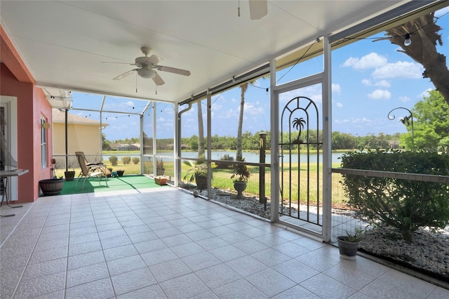 unfurnished sunroom featuring a water view and ceiling fan