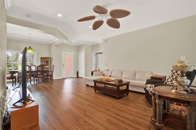 living room featuring ceiling fan, ornamental molding, and hardwood / wood-style flooring