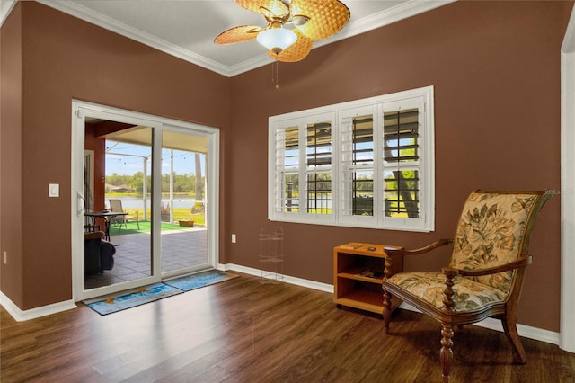 sitting room featuring ceiling fan, crown molding, and dark wood-type flooring