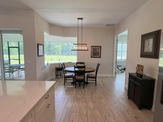 dining area featuring a chandelier and light wood-type flooring