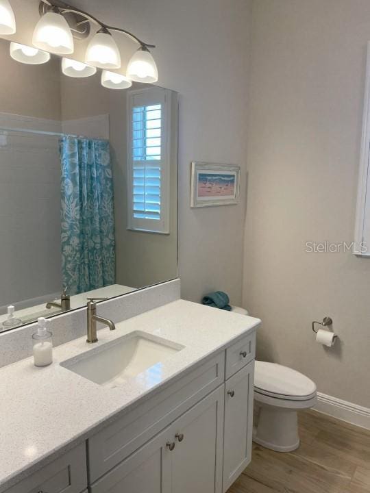 bathroom with vanity, curtained shower, wood-type flooring, and toilet