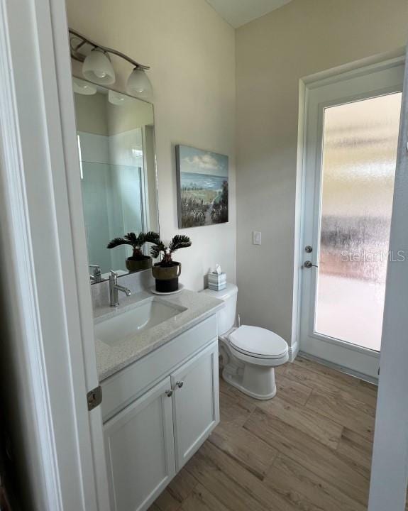 bathroom featuring vanity, hardwood / wood-style floors, and toilet