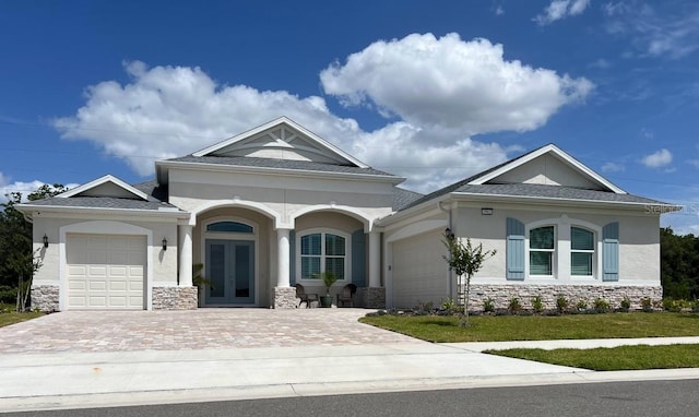 3962 Kennebunk Loop, Mount Dora, FL 32757 - view of front of home with french doors, stone siding, a garage, stucco siding, and driveway