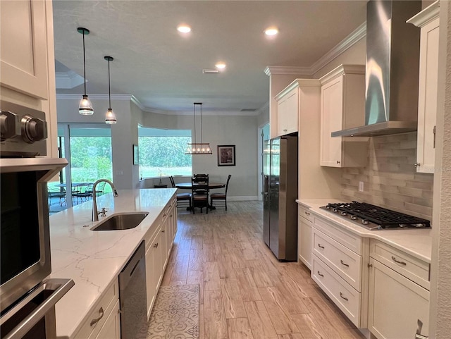 3962 Kennebunk Loop, Mount Dora, FL 32757 - kitchen with stainless steel appliances, wall chimney range hood, a sink, crown molding, and white cabinetry