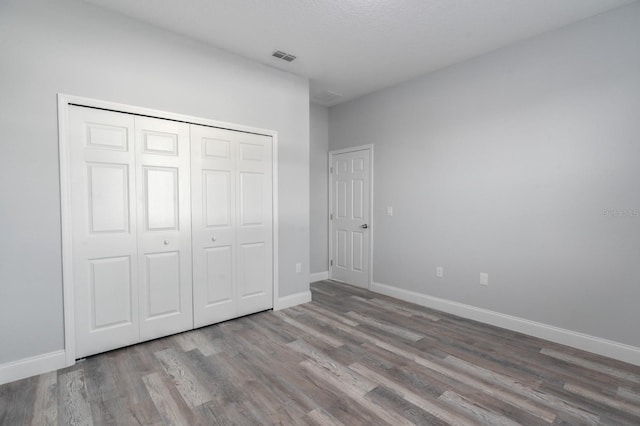 unfurnished bedroom featuring wood-type flooring and a closet