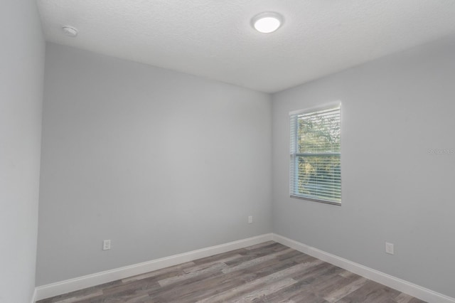 empty room featuring hardwood / wood-style flooring and a textured ceiling