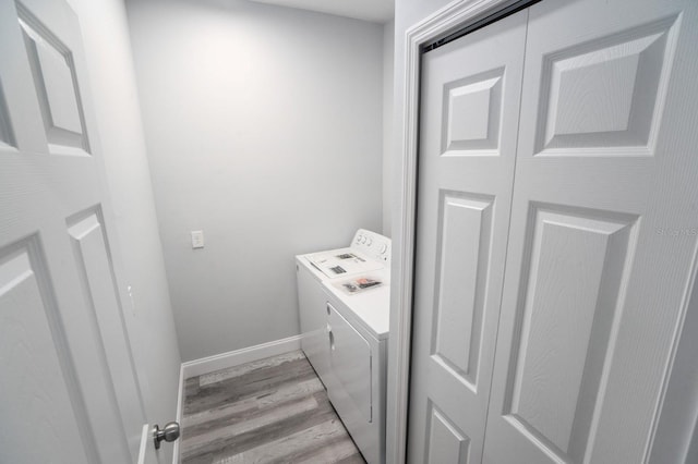 washroom with washing machine and dryer and light wood-type flooring