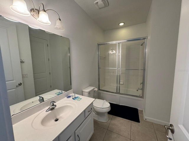 full bathroom featuring shower / bath combination with glass door, oversized vanity, tile floors, and toilet