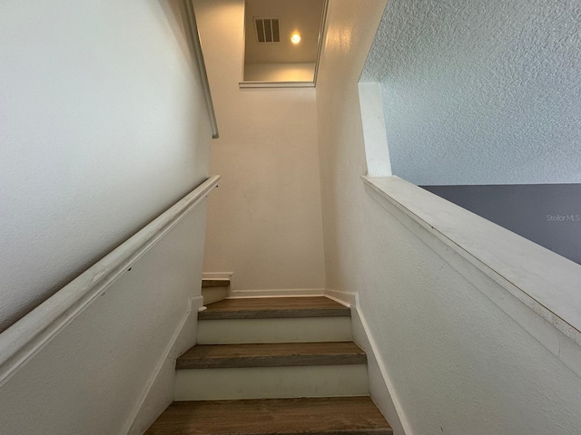 stairs featuring hardwood / wood-style flooring