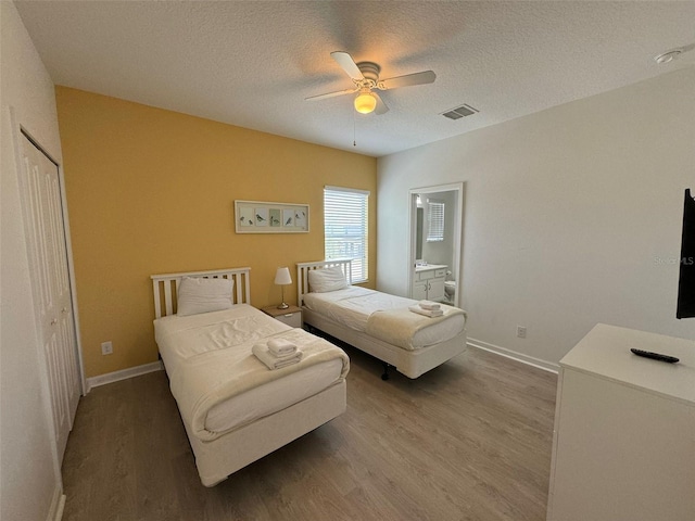 bedroom featuring a closet, wood-type flooring, ceiling fan, and ensuite bathroom