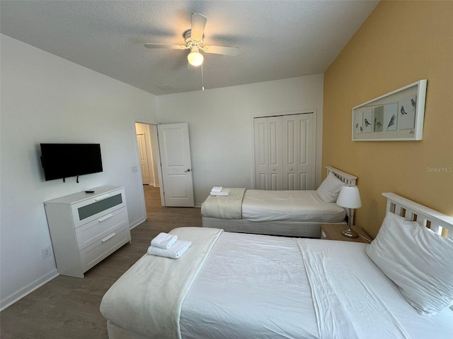 bedroom featuring a closet, dark hardwood / wood-style floors, and ceiling fan