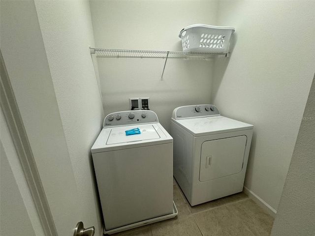 laundry room featuring washing machine and dryer, light tile floors, and hookup for a washing machine