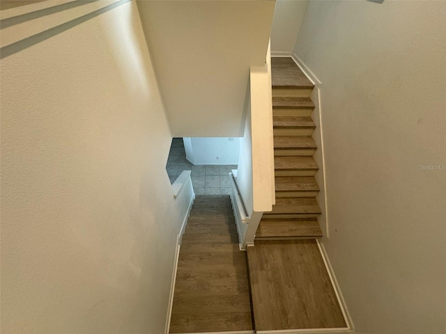 stairway with dark hardwood / wood-style flooring