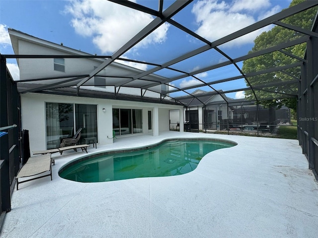 view of pool featuring a patio area and glass enclosure