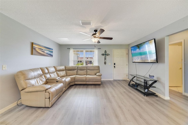 living room with light hardwood / wood-style flooring, ceiling fan, and a textured ceiling