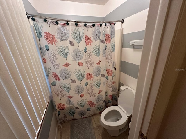 bathroom featuring toilet, a shower with curtain, and tile patterned flooring