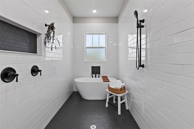 bathroom featuring tile patterned floors, tile walls, and a bathing tub