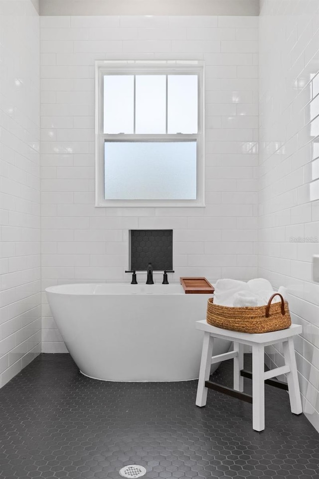 bathroom with tile patterned floors and a tub