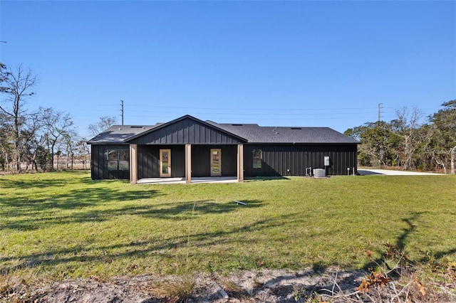 back of property featuring central AC unit and a yard