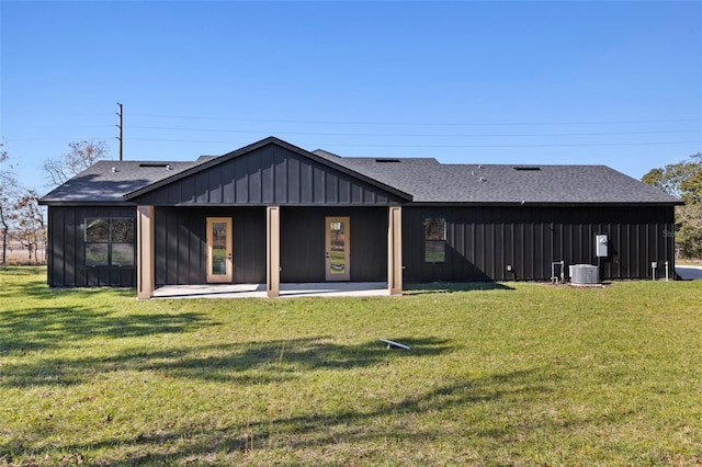 rear view of property featuring a lawn, central AC, and a patio