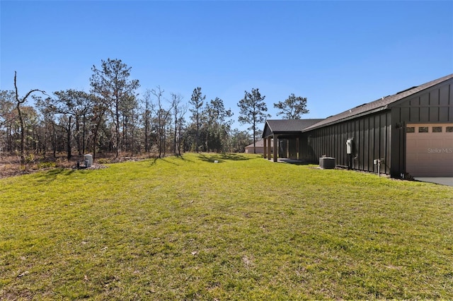 view of yard featuring central AC and a garage