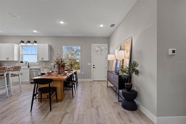 dining room with sink and light wood-type flooring