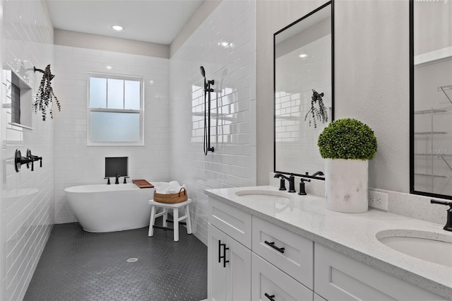 bathroom with a bath, vanity, and tile walls