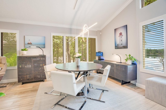 dining space with lofted ceiling, ornamental molding, and light wood-type flooring