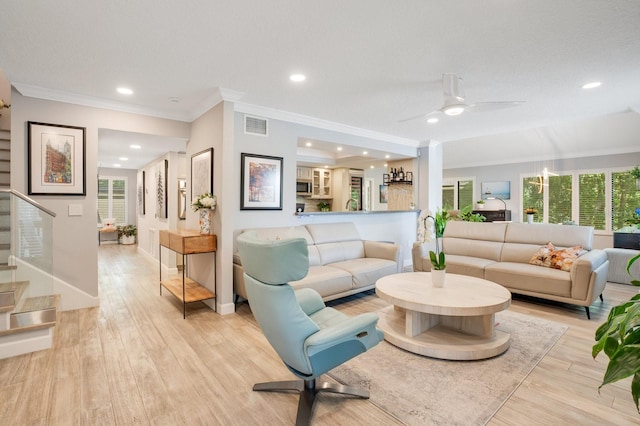 living room featuring ornamental molding, ceiling fan, and light hardwood / wood-style flooring