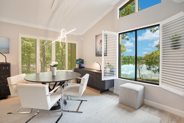 dining space featuring a water view, lofted ceiling, ornamental molding, and light wood-type flooring