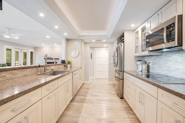 kitchen with sink, crown molding, appliances with stainless steel finishes, backsplash, and light stone counters