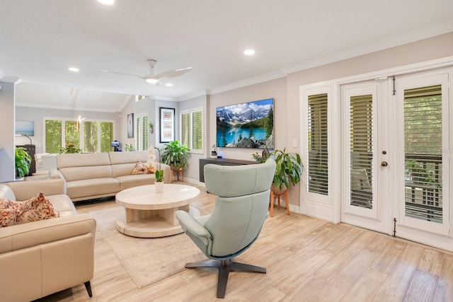 living room with ornamental molding, ceiling fan, and light hardwood / wood-style flooring