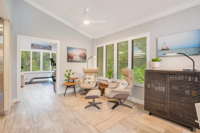 sitting room with vaulted ceiling, ornamental molding, ceiling fan, and light wood-type flooring