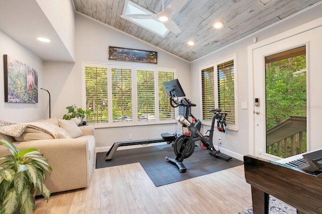 exercise room with lofted ceiling with skylight, light wood-type flooring, and wood ceiling