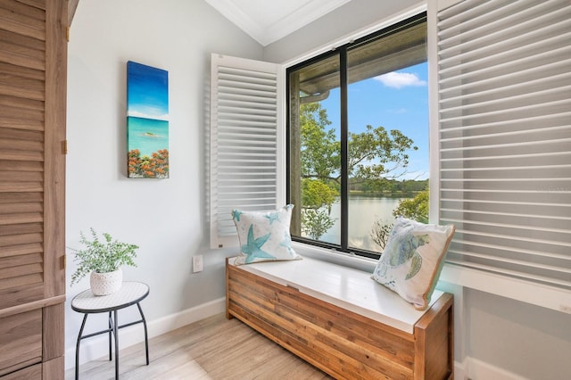 living area featuring crown molding, a water view, lofted ceiling, and light wood-type flooring