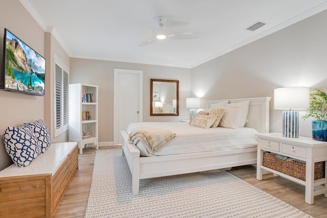 bedroom featuring ornamental molding, ceiling fan, and light wood-type flooring