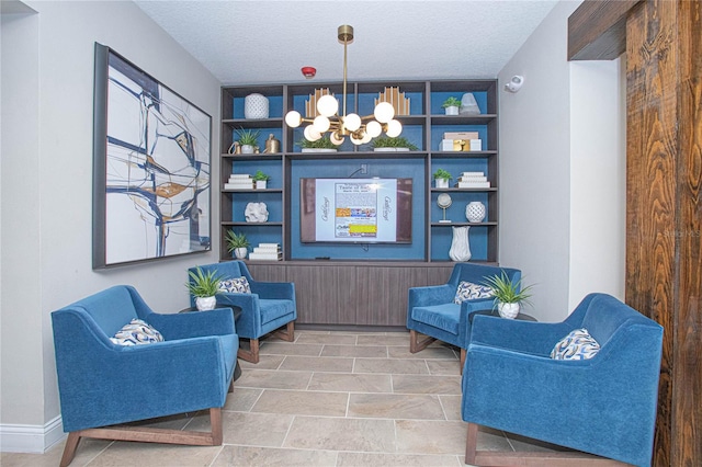 living area with an inviting chandelier, tile floors, and a textured ceiling