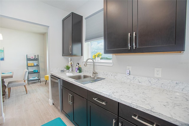 kitchen with light hardwood / wood-style flooring, sink, light stone counters, dishwasher, and dark brown cabinetry