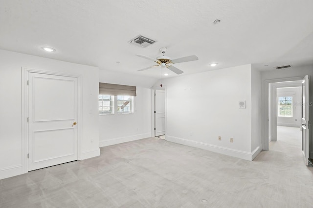 carpeted empty room with plenty of natural light and ceiling fan