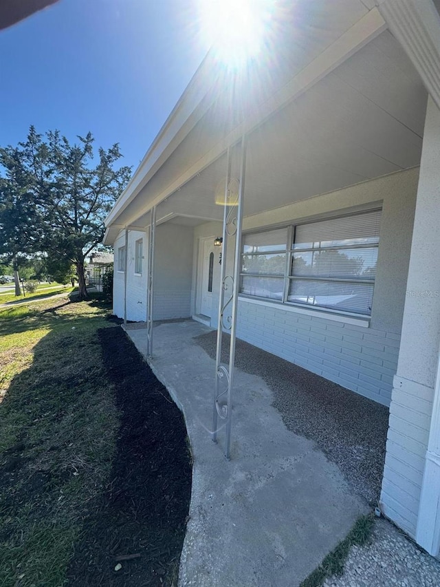 view of side of property featuring a patio and a lawn