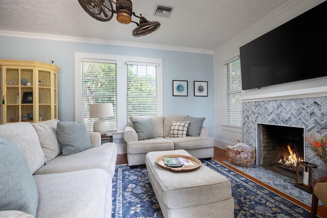 living room with ornamental molding, dark hardwood / wood-style floors, a textured ceiling, and a fireplace