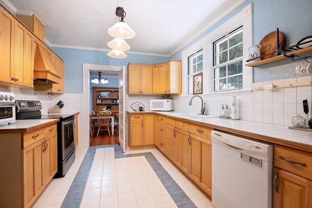 kitchen with backsplash, white appliances, tile countertops, sink, and ornamental molding